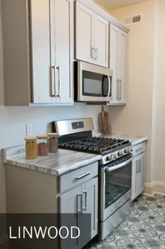 a kitchen with white cabinets and a stove and a microwave  at Cincinnati Premier Living*, Cincinnati, OH