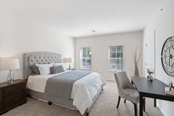 A bedroom with a large bed, a chair, and a table. at Roebling Row, Covington, 41011-1720