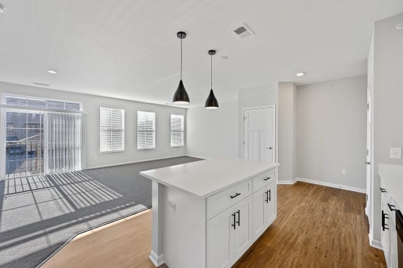 an open kitchen and living room with white cabinets and a white island at Monmouth Row Apartments, Newport, 41071