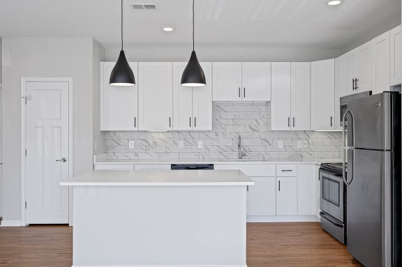 a white kitchen with stainless steel appliances and white cabinets at Monmouth Row Apartments, Newport, 41071