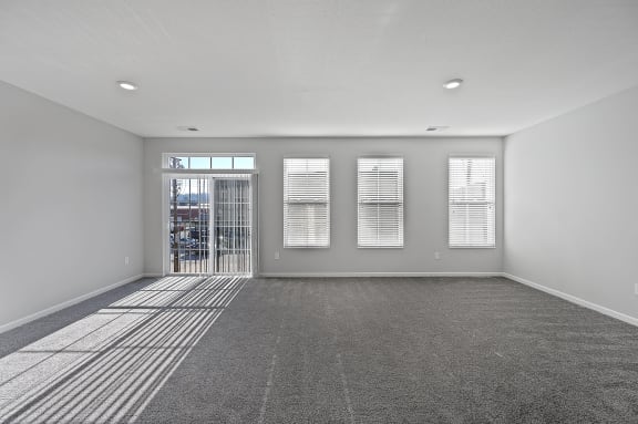 an empty living room with a door to a balcony at Monmouth Row Apartments, Newport, KY