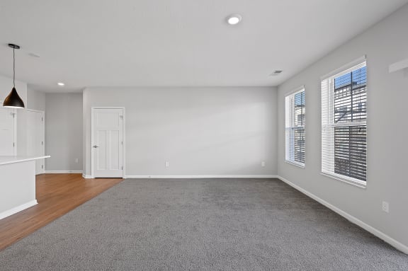 an empty living room with white walls and wood flooring at Monmouth Row Apartments, Newport, Kentucky