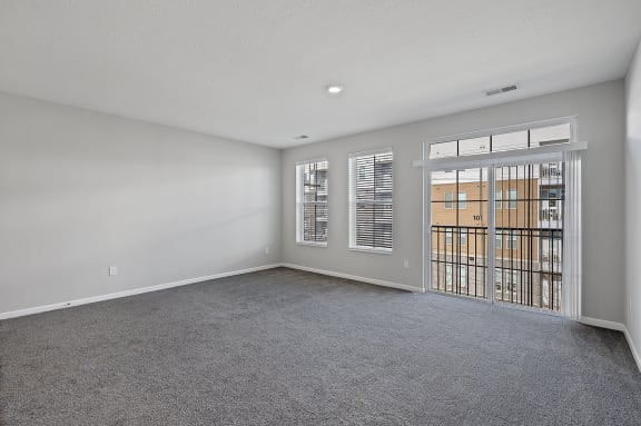 an empty living room with a door to a balcony at Monmouth Row Apartments, Kentucky
