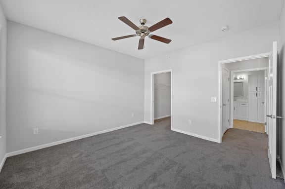 a bedroom with a ceiling fan and a door to a hallway at Monmouth Row Apartments, Newport, KY