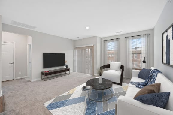 a living room with a couch and a chair and a television at Monmouth Row Apartments, Newport, KY, 41071