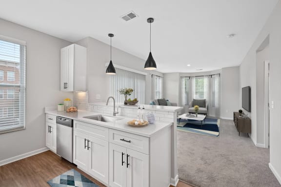 an open kitchen and living room with white cabinets and a white counter top at Monmouth Row Apartments, Newport
