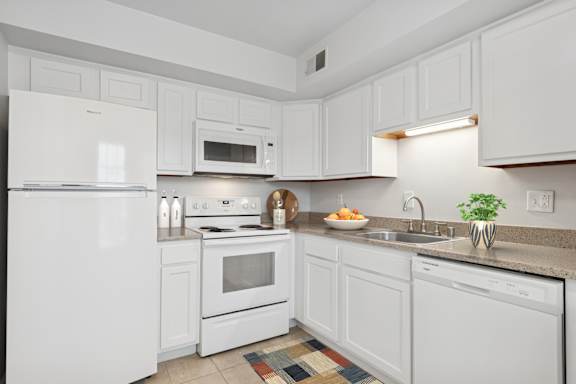 A kitchen with white appliances and cabinets.