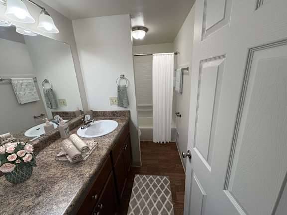 A bathroom with a marble countertop and a large mirror above it.