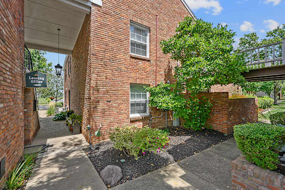 a side view of a brick building with a tree and a sidewalk at Olde Towne in Kenwood, Cincinnati, OH, 45243