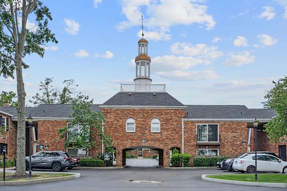 a brick church with a steeple and cars parked in front at Olde Towne in Kenwood, Cincinnati, 45243