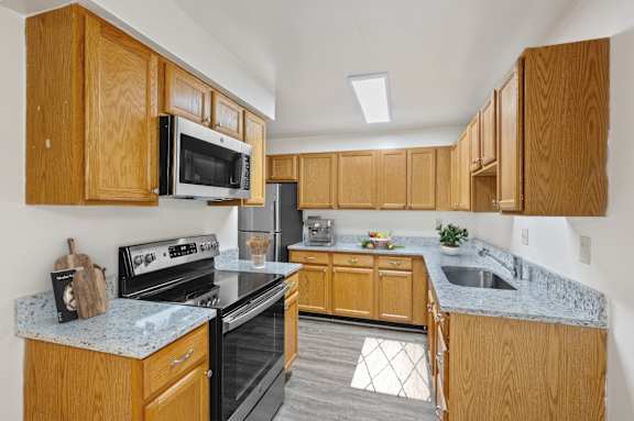 A kitchen with wooden cabinets and granite countertops. at Indian Creek Apartments*, Ohio, 45236