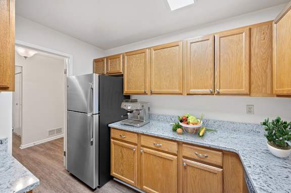 A kitchen with wooden cabinets and a marble countertop. at Indian Creek Apartments*, Ohio, 45236
