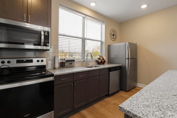 a kitchen with granite counter tops and stainless steel appliances at Adelphi Quarter, Columbus, Ohio