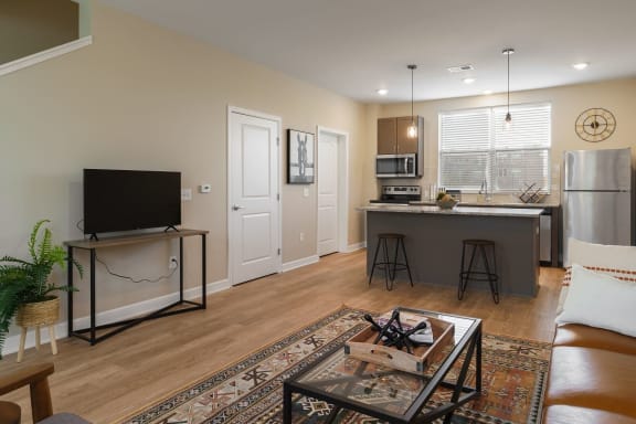 an open living room and kitchen with a couch and a tv at Adelphi Quarter, Columbus