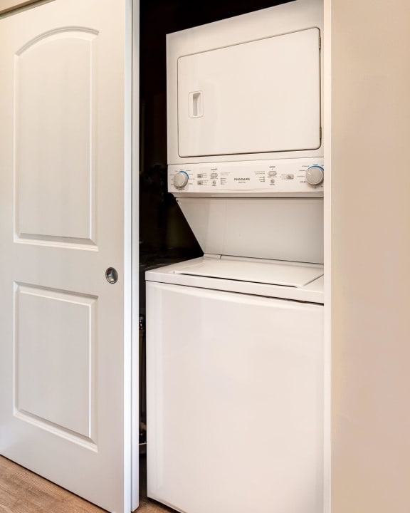 a washer and dryer in a closet next to a white door at Adelphi Quarter, Columbus, OH, 43203