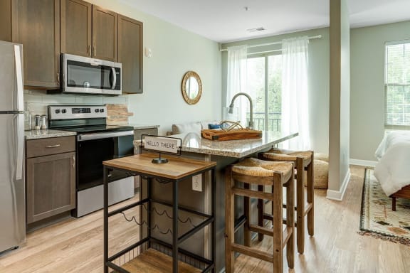 a kitchen with a center island with wooden stools at Adelphi Quarter, Columbus, Ohio