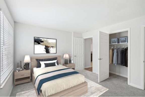 A bedroom with a bed, nightstands, and a closet.