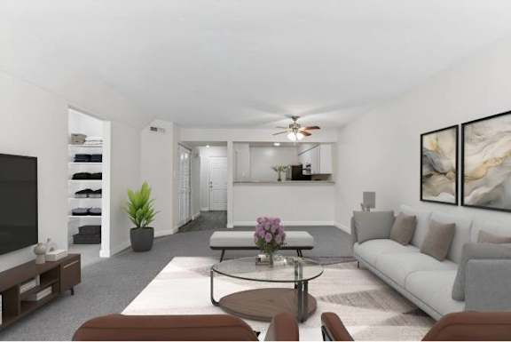 A modern living room with a grey sofa, a glass coffee table, and a TV on the left side.
