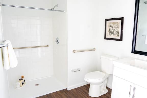 A white toilet sits in a bathroom next to a white sink.