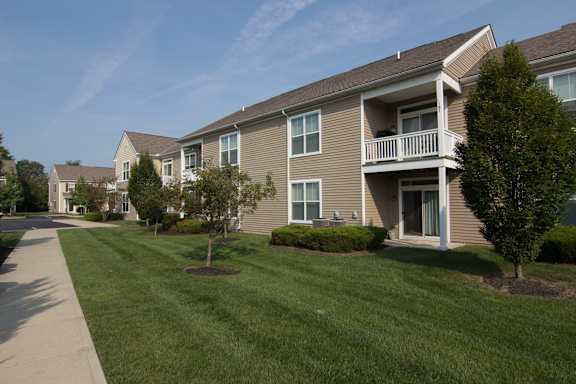 A row of houses with a sidewalk in front.