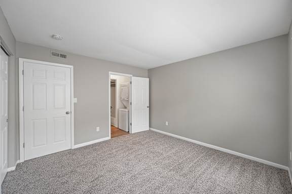 A room with a white door and a carpeted floor.