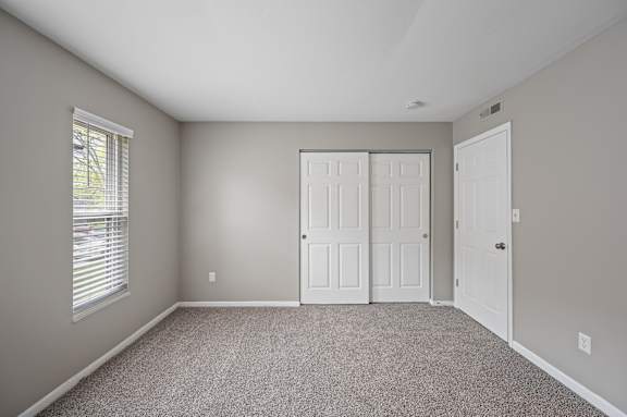 A room with a carpeted floor and a white door.
