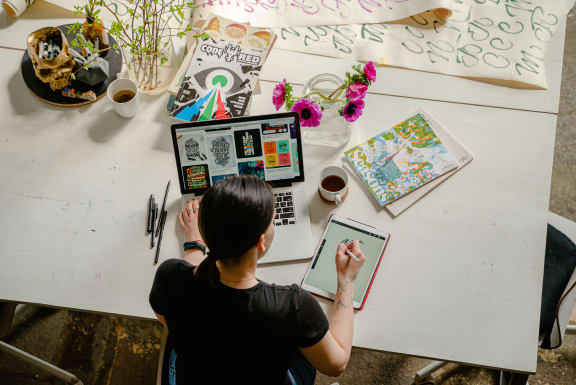 Woman sitting at a desk with a laptop and tablet at Indian Lookout, West Carrollton, OH
