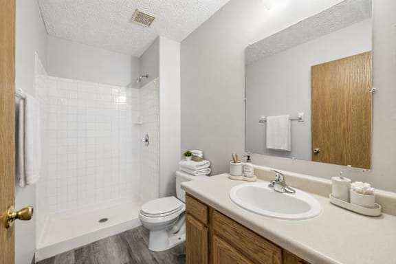 A white bathroom with a toilet, sink, and shower.