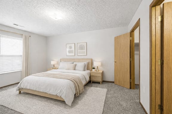 A bedroom with a large bed and two nightstands.