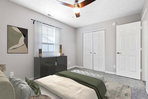 an empty bedroom with a bed and a ceiling fan at Parkview of Lebanon Apartments, Lebanon, IN