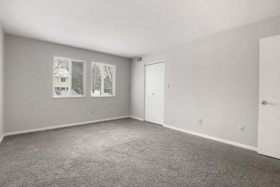 A room with grey carpet and white walls.