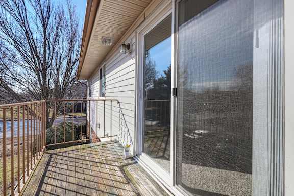 A deck with a railing and sliding glass doors.