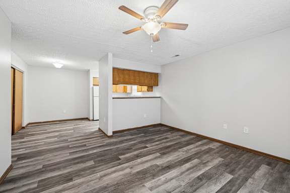A room with a ceiling fan and wooden flooring.