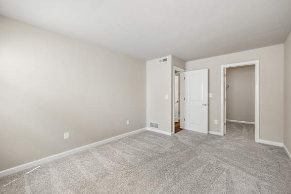 A room with a carpeted floor and a white door.