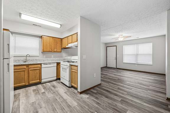 A kitchen with wooden cabinets and a white fridge.