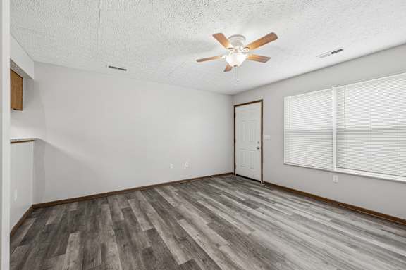 A room with a ceiling fan and wooden flooring.