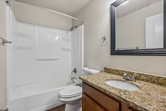 A bathroom with a white toilet, a sink, and a shower.