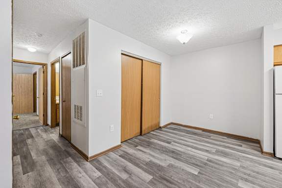 A hallway with wood floors and white walls.