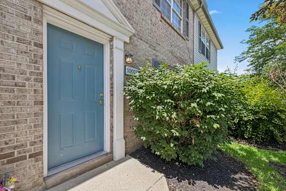 A blue door is on the left side of a brick house.