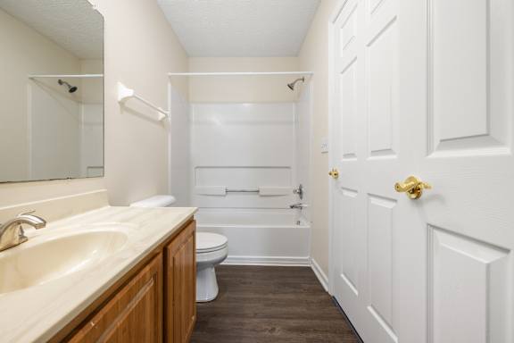A white bathroom with a sink, toilet, and bathtub.