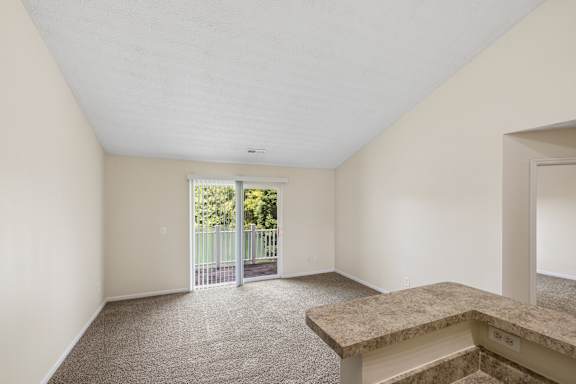 A room with a carpeted floor and a marble bench.