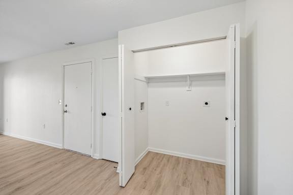 A white room with a closet and a door.
