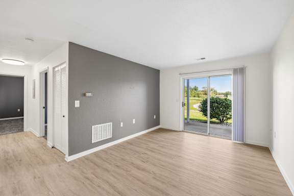A room with a sliding glass door leading to a garden.