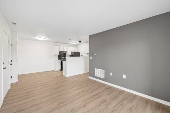 A room with a white door and a white fridge.