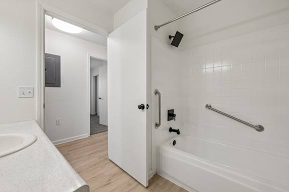 A white bathroom with a white tub and a white sink.