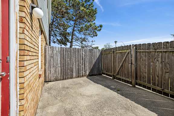 A wooden fence surrounds a small yard.