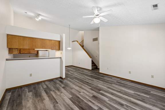 A room with a wood floor and a ceiling fan.
