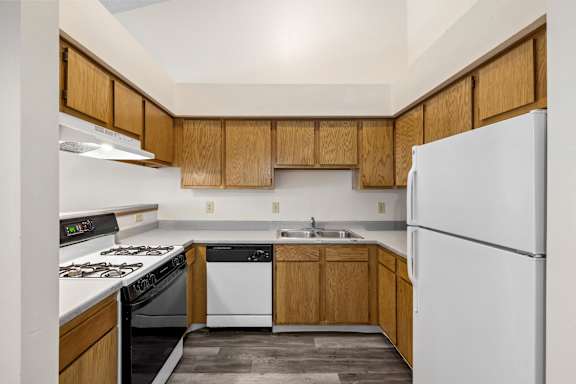 A kitchen with wooden cabinets and a white refrigerator.