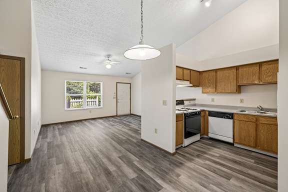 A kitchen with wooden cabinets and a grey floor.