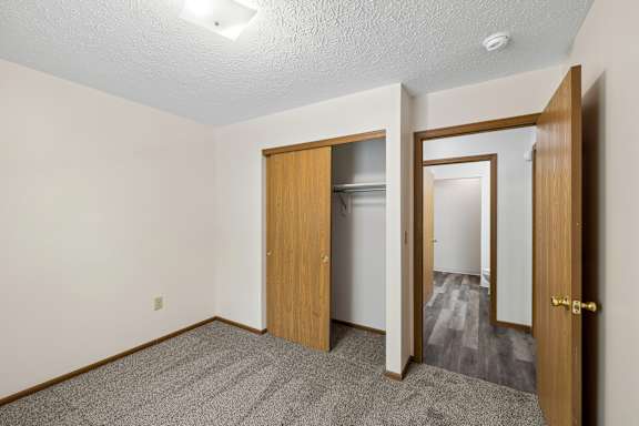 A room with a carpeted floor and a wooden door.
